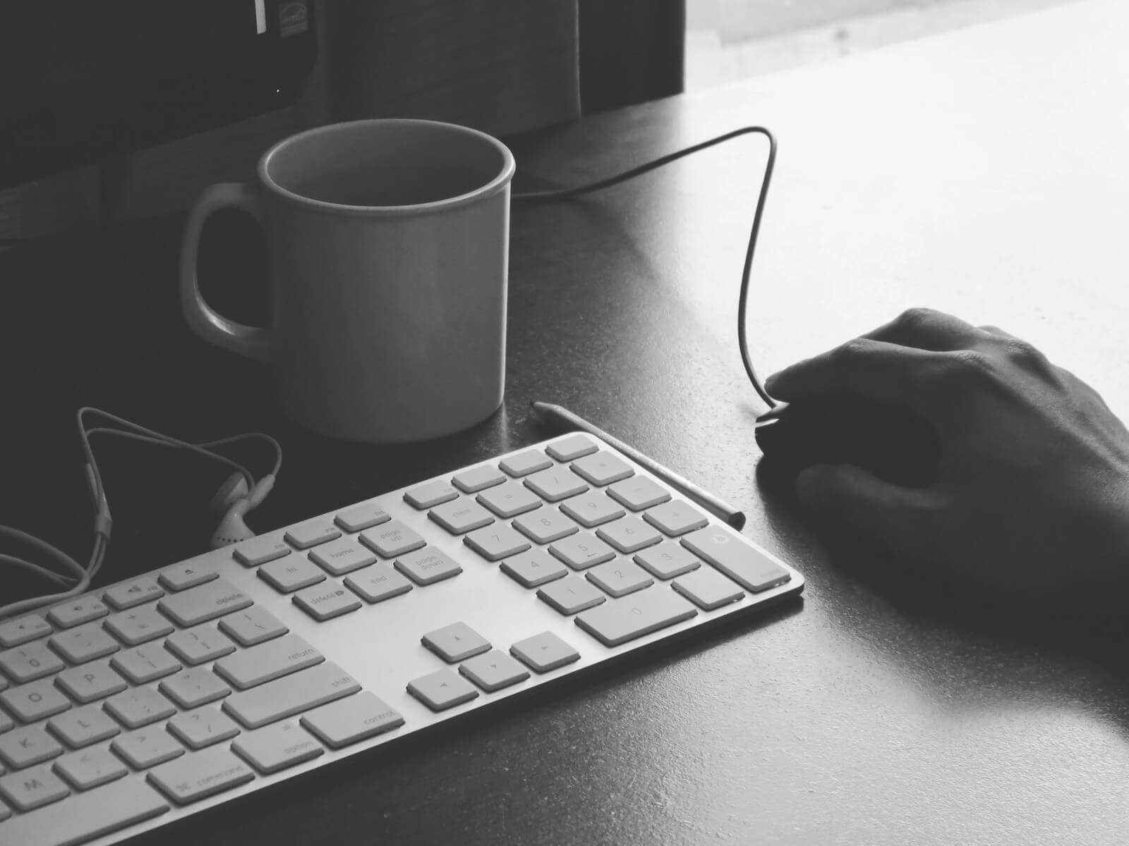 Keyboard, mouse and coffee at a workstation